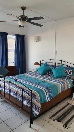 a bedroom with a large bed with blue pillows at Stella Maris 53 in Amanzimtoti
