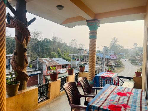 a balcony with a table and chairs and a view of a street at Tiger Corner Inn Homestay in Sauraha