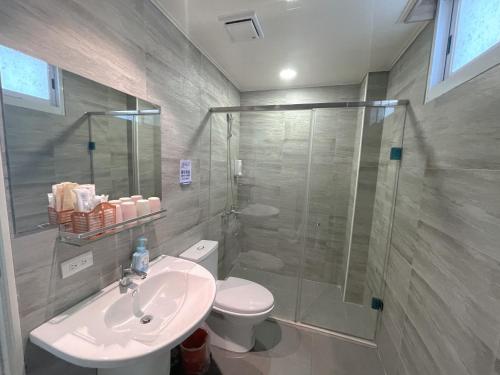 La salle de bains est pourvue d'une douche, de toilettes et d'un lavabo. dans l'établissement Breeze and Waves Hostel, à Jinning