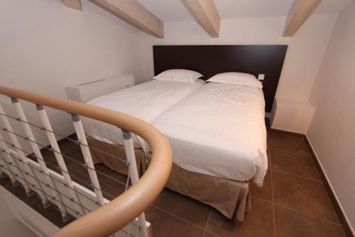 a bed with white sheets and pillows in a room at Hôtel A Madonetta in Bonifacio