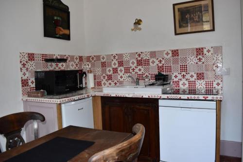 a kitchen with a sink and a table in it at gite d'Albertine in Ully-Saint-Georges