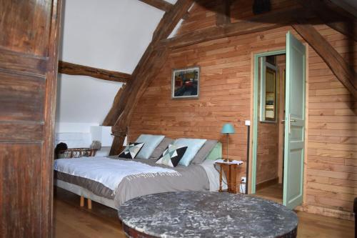 a bedroom with two beds in a room with wooden walls at gite d'Albertine in Ully-Saint-Georges