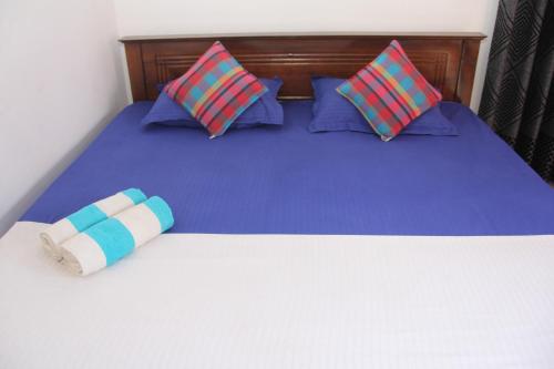 a bed with blue sheets and blue pillows at Sandaru Holiday Resort in Weligama