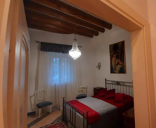 a bedroom with a red bed and a chandelier at Casa Giulia in Rodengo Saiano