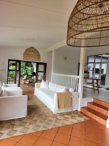 a living room with white couches and a rug at Imasiku House in Southbroom