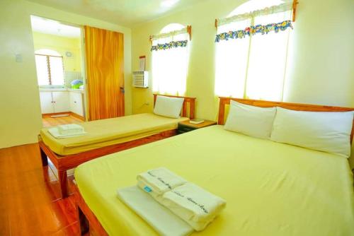 um quarto de hotel com duas camas e duas janelas em Necy's Homestay em Basco