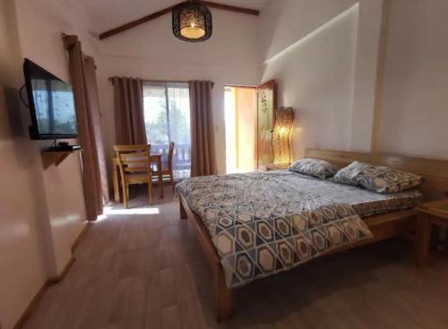 ein Schlafzimmer mit einem Bett und einem TV in der Unterkunft Saschas Place in Siquijor
