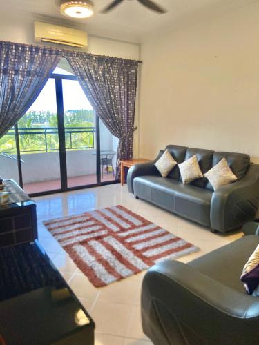 a living room with two couches and a large window at Homestay Legacy Kamariah Ahmad,Lumut in Lumut