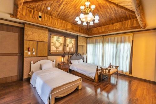 duża sypialnia z 2 łóżkami i żyrandolem w obiekcie Jeju Nine Resort w mieście Czedżu