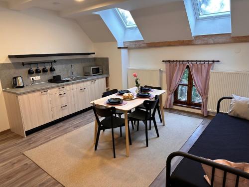 a kitchen and living room with a table and chairs at Apartmány na mlýně in Nové Město na Moravě