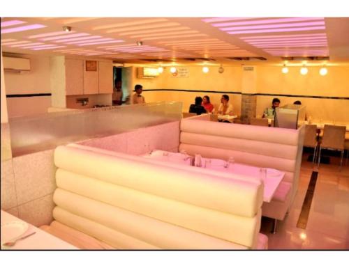 un restaurante con gente sentada en una sala de espera en Hotel Pearl,Indore en Indore