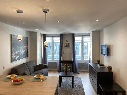 a living room with a couch and a table at Maison le Bac Paris Aparthotel in Paris