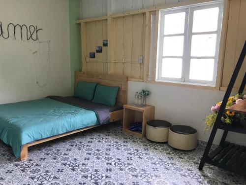 1 dormitorio con cama y ventana en Thanh Ngọc Homestay Đà Lạt, en Ấp Kim Thạch