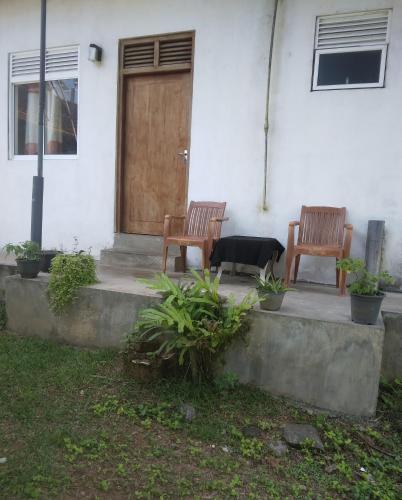 two chairs sitting in front of a house with a door at SunRay Rest - Beach View Homestay in Mirissa