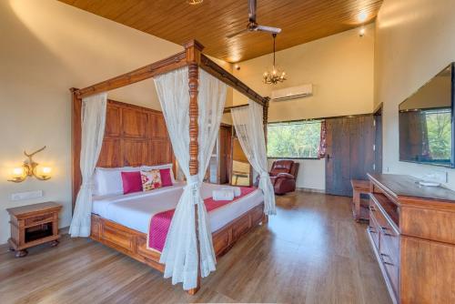 a bedroom with a canopy bed in a room at SaffronStays Althea - 4 BRD Veg Only Villa In Pawna With Jacuzzi In Every Room in Lonavala
