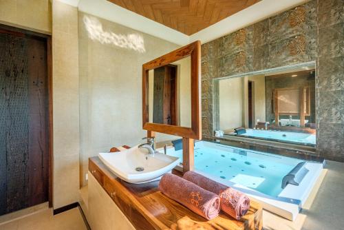 a bathroom with a sink and a tub at SaffronStays Althea - 4 BRD Veg Only Villa In Pawna With Jacuzzi In Every Room in Lonavala