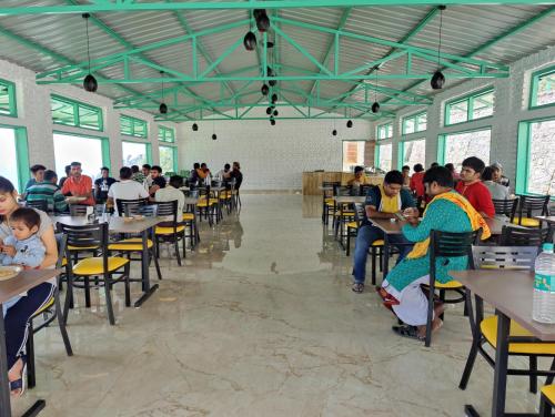 um grupo de pessoas sentadas em mesas em uma sala em LaSerene The Cottage - Pangoot em Nainital