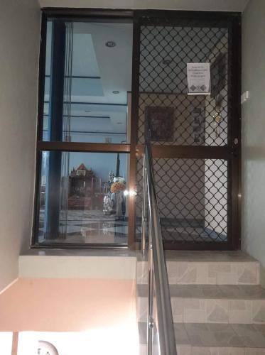 a staircase with a gate and a glass window at Karans Apartment in Varoka