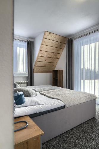 a bedroom with a large bed with a wooden ceiling at Wiyrchowianka in Gliczarów Górny