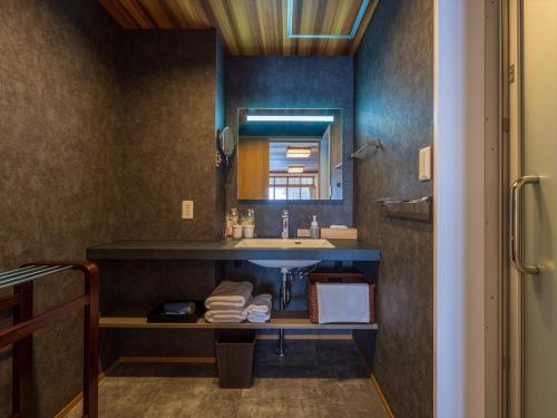 熱海的住宿－熱海溫泉山木日式旅館，一间带水槽和镜子的浴室