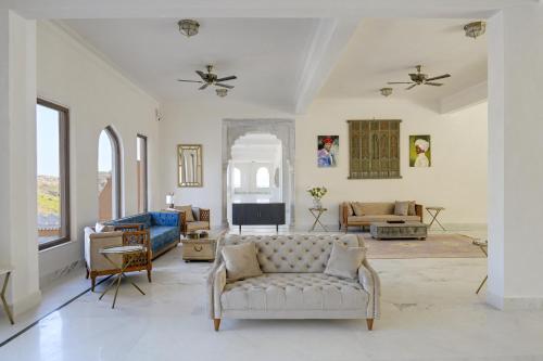 a living room with a couch and a tv at Fateh Vilas by Fateh Collection in Udaipur