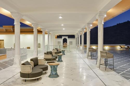 a lobby with chairs and tables in a building at Fateh Vilas by Fateh Collection in Udaipur