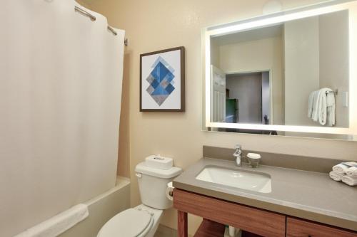a bathroom with a toilet and a sink and a mirror at Candlewood Suites Idaho Falls by IHG in Idaho Falls