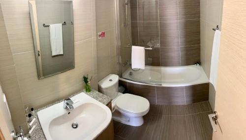 a bathroom with a white toilet and a sink at Mythical Sands Resort - Antonios in Paralimni