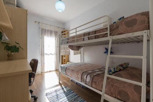 a bedroom with two bunk beds and a window at Casa Del Olivo in Algeciras