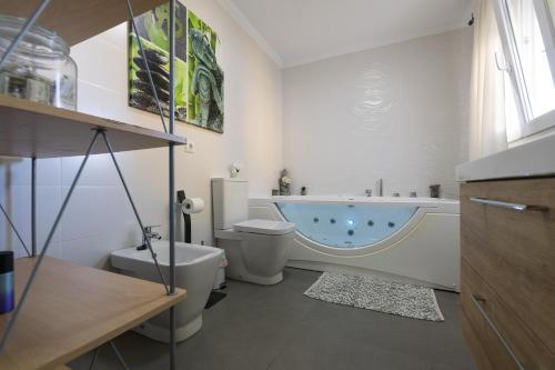 a bathroom with a tub and a toilet and a sink at Casa Del Olivo in Algeciras
