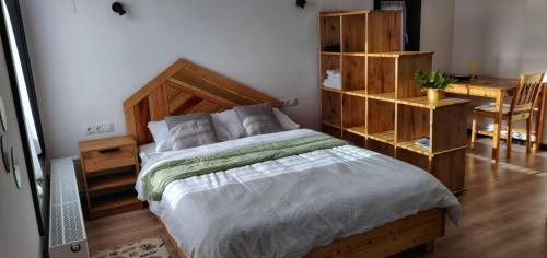 a bedroom with a large bed and a desk at Birtok Houses- twin no 1 for 2 people in Borzont