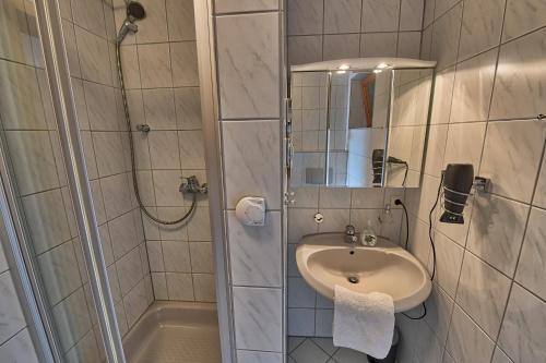 a bathroom with a sink and a shower with a mirror at Ersfeld - Bad Teinach Zavelstein in Bad Teinach-Zavelstein