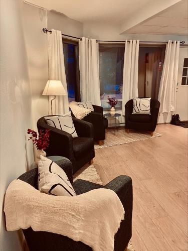 a living room with couches and chairs and windows at First Camp Moraparken Hotel in Mora