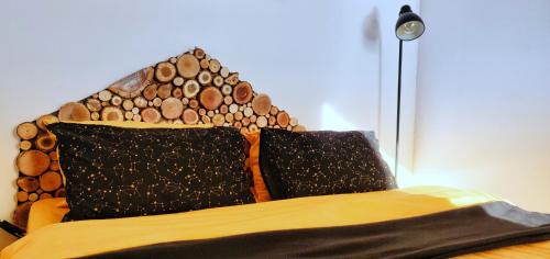 a bed with a wooden headboard with two pillows at Birtok Houses - twin no. 2 for 2 people in Borzont