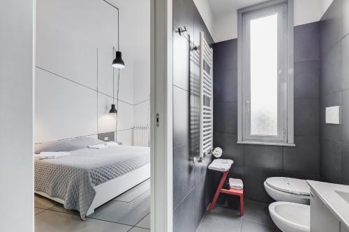 1 dormitorio con cama, aseo y lavamanos en The Upper Suites, en Roma