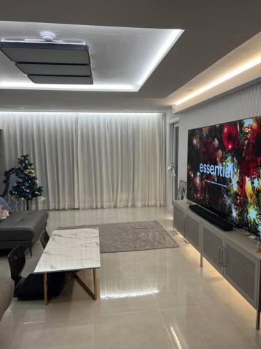 a living room with a large television and a christmas tree at Cozy Space with Modern Interior in Hwaseong in Hwaseong