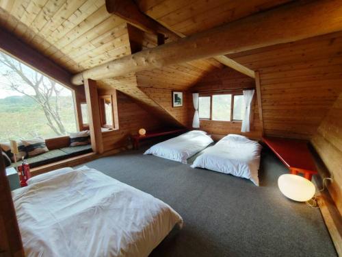 a bedroom with two beds in a log cabin at RENEST in Kobe