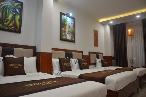 a group of four beds in a hotel room at Hào Hoa Hotel Kon Tum in Kon Tum