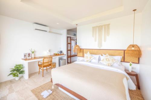 a bedroom with a white bed and a desk at The AVA Resort Koh Tao in Koh Tao