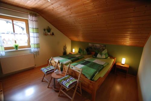 a bedroom with two beds and a wooden ceiling at Ferienwohnung Christina in Mauth