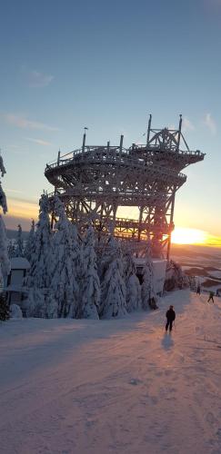 a person skiing in the snow in front of a structure at Apartmán Cardovi in Dolní Morava
