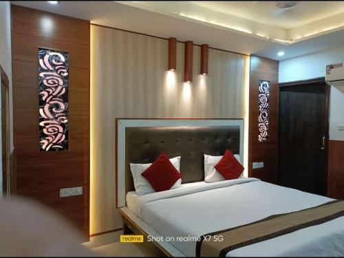 1 dormitorio con 1 cama blanca grande con almohadas rojas en Bedweiser Backpackers Hostel, en Agra