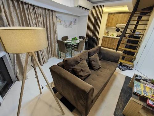 sala de estar con sofá y mesa en A2J Luxury 2BR Suite Near High Street BGC Taguig, en Manila