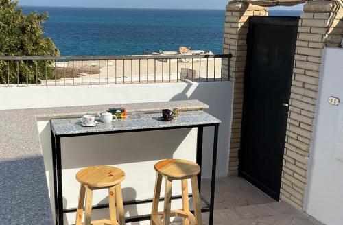 een tafel en twee stoelen op een balkon met uitzicht op de oceaan bij Mini-Studio With Free Private Beach in Hurghada