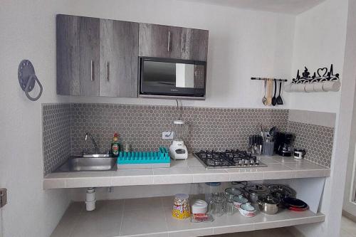 a small kitchen with a sink and a microwave at Casa el conquistador/ExcelenteUbicación/2Hab/Wifi in Mérida