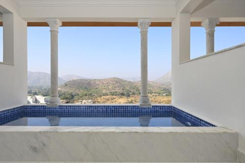 a swimming pool with a view of the mountains at Fateh Vilas by Fateh Collection in Udaipur