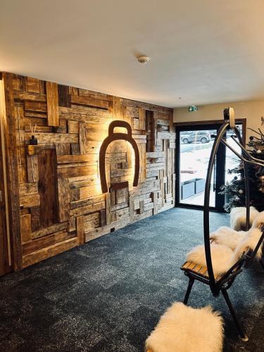 a room with a wooden wall with a chair in front at Hameau des Prodains - Résidence in Morzine
