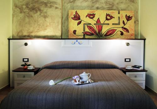 a bedroom with a bed with a teapot on a tray at Agriturismo Montalbano in Cartabubbo