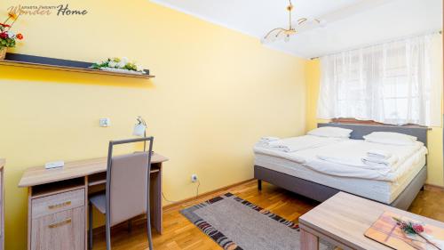 1 dormitorio con cama, escritorio y mesa en Wonder Home - Apartament Grey w spokojnej okolicy - blisko terenów zielonych, en Karpacz