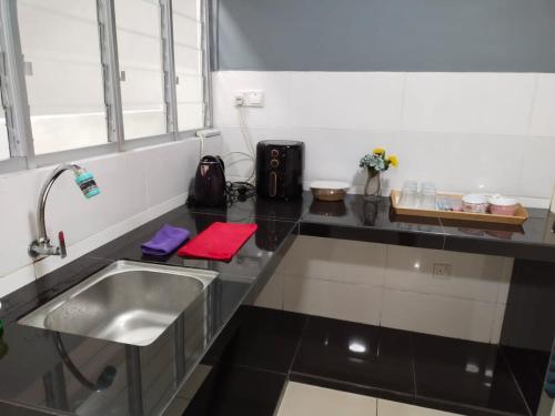 eine Küche mit einer Spüle und einer Arbeitsplatte in der Unterkunft 3 bedrooms big house saville cheras MRT with balcony in Cheras